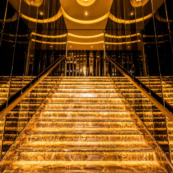 Gold-and-black grand staircase with illuminated ceiling