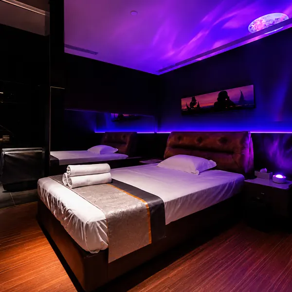 Purple-lit twin-bed themed suite