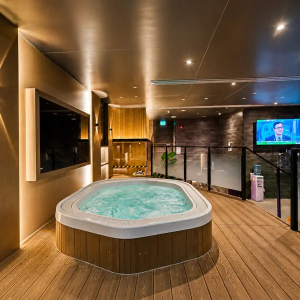 Round soaking tub beside a TV wall
