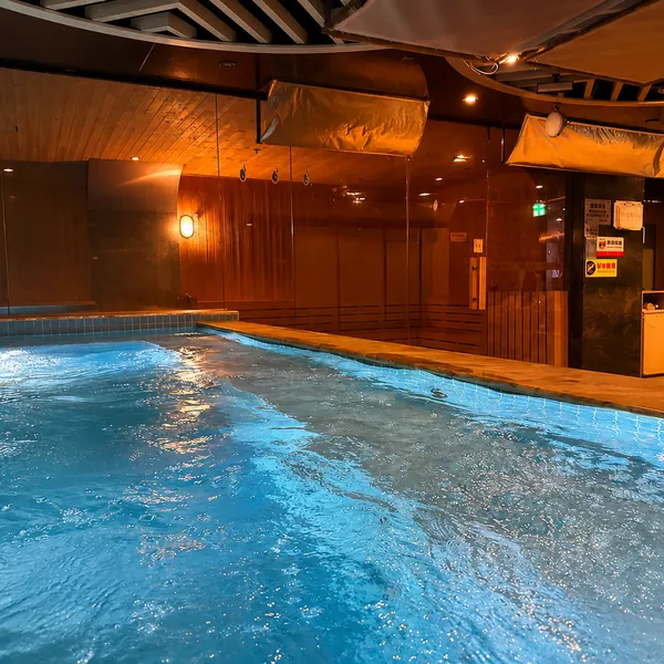 Blue jacuzzi pool with wood-toned walls