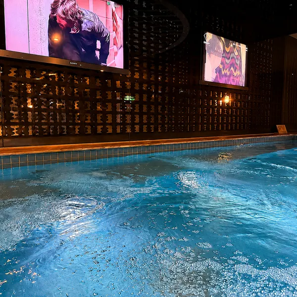 Large bathing pool with a TV wall